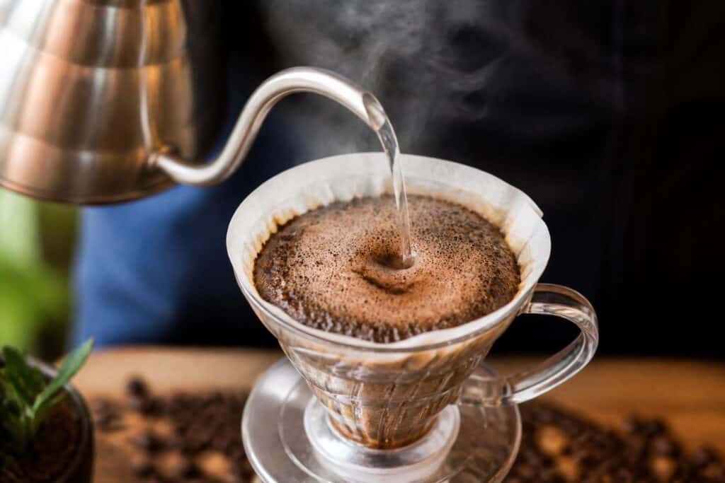 Hot water being poured over coffee grounds in a pour-over brewer.